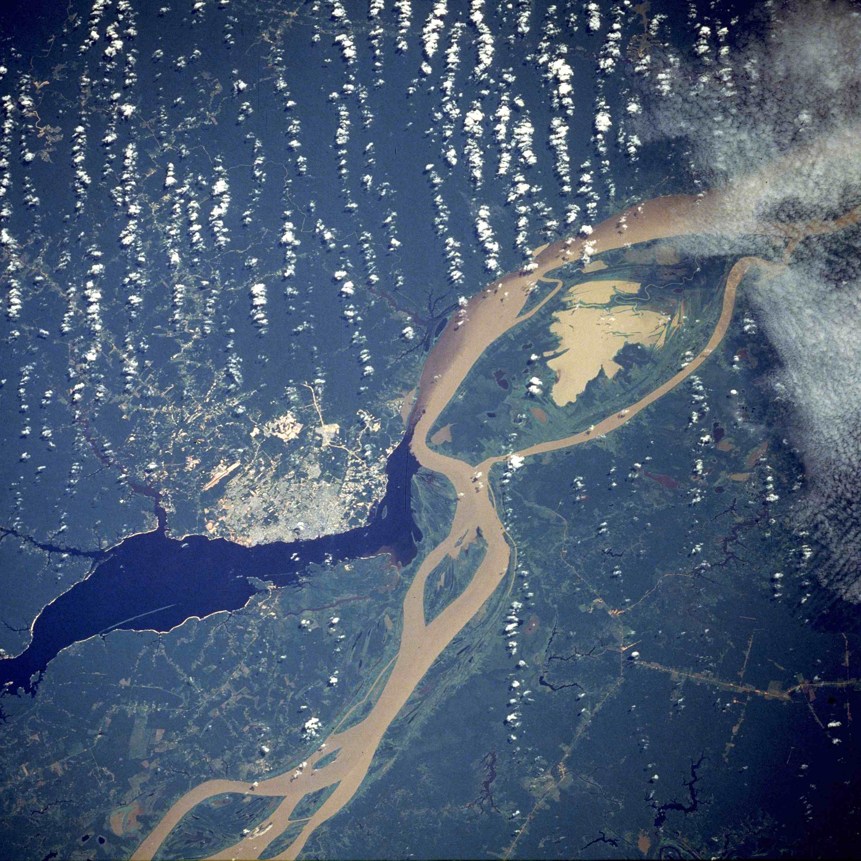 Manaus, the largest city in Amazonas, as seen from a NASA satellite image, surrounded by the dark Rio Negro and the muddy Amazon River.