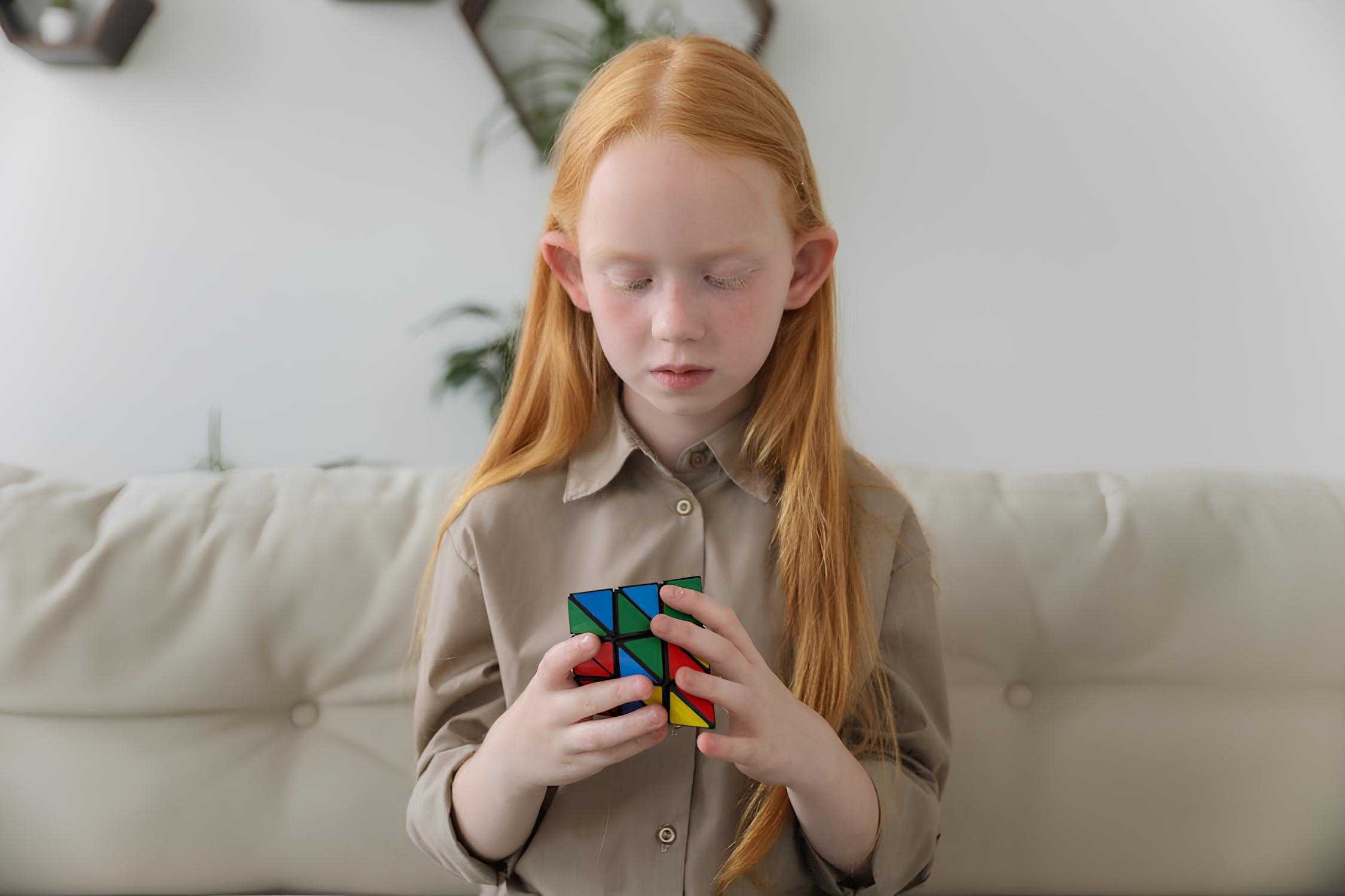 IQ brain cute girl thinking over bright puzzle cube