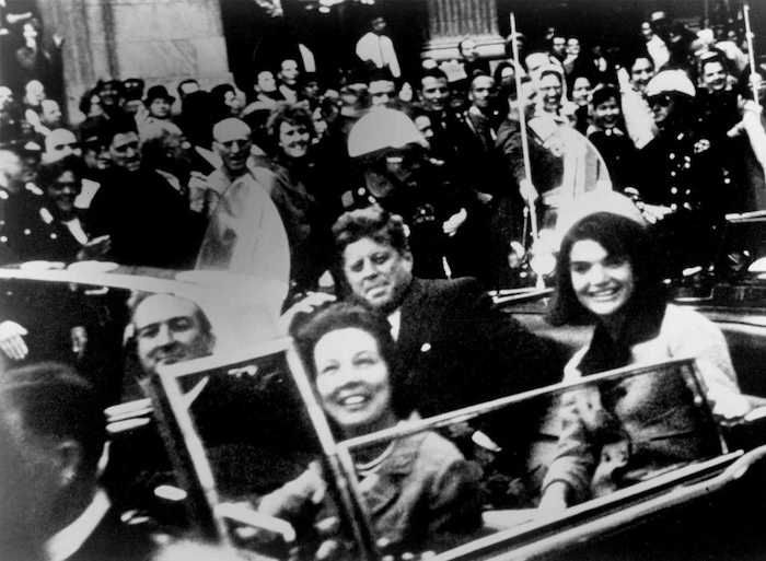 John F. Kennedy salue le public pour la dernière fois dans un cortège.